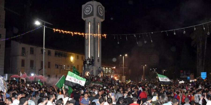 احتفالات في ساحة الساعة الجديدة بحمص بعد قرار الرئيس ترامب رفع العقوبات المفروضة على سوريا - تليجراف الخليج